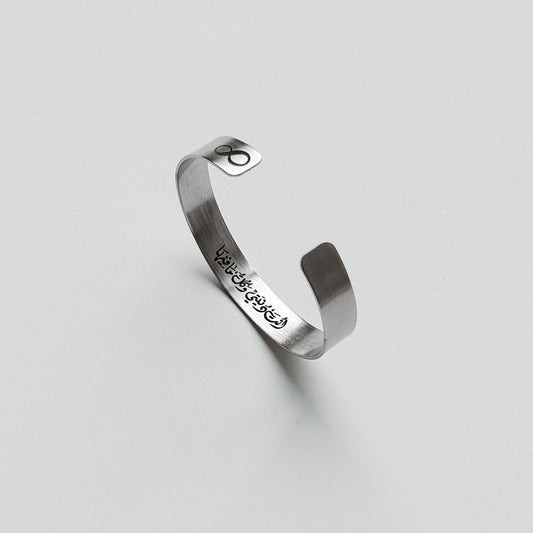Silver bracelet with engraved text on a light gray background